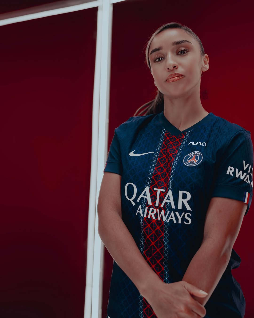 A woman wearing Paris Saint-Germain 2025-2026 home kit