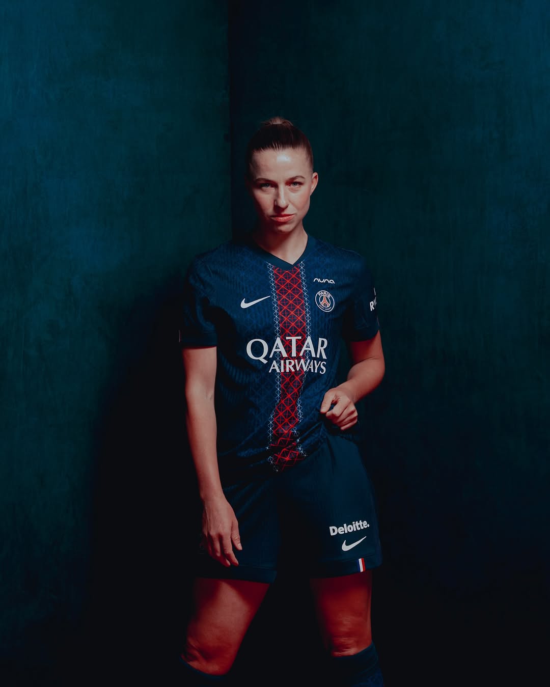 A woman wearing Paris Saint-Germain 2025-2026 Home Kit