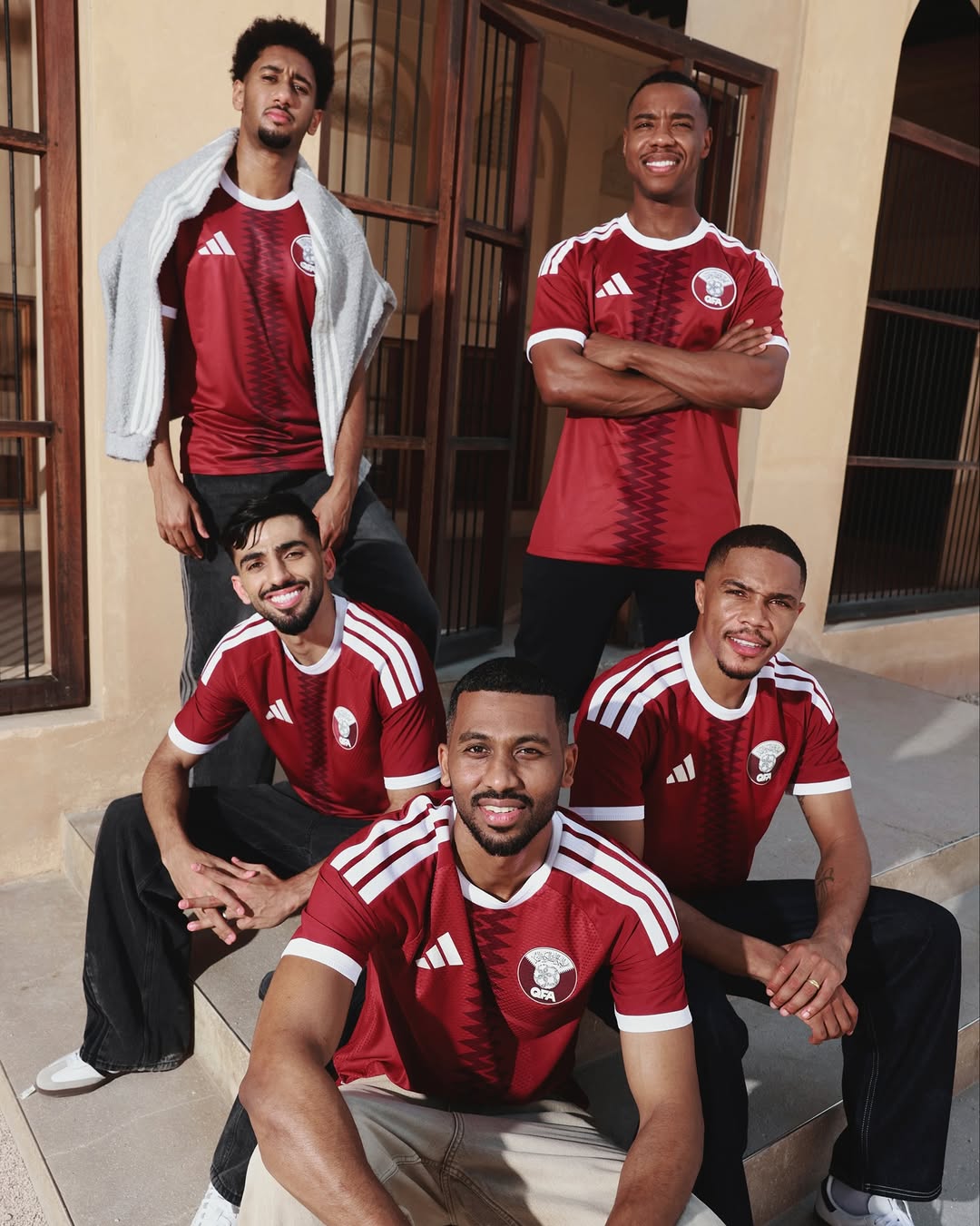 Players of Qatar wearing Qatar 2026 world cup home kit